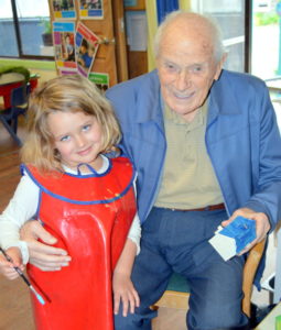 Ella Huntly helps Sidney Thomas paint one of the houses for the model train table.